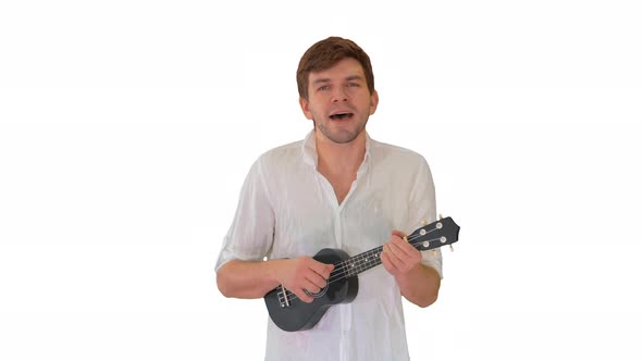 Young Man Playing Ukulele and Signing While Walking and Looking Into Camera on White Background