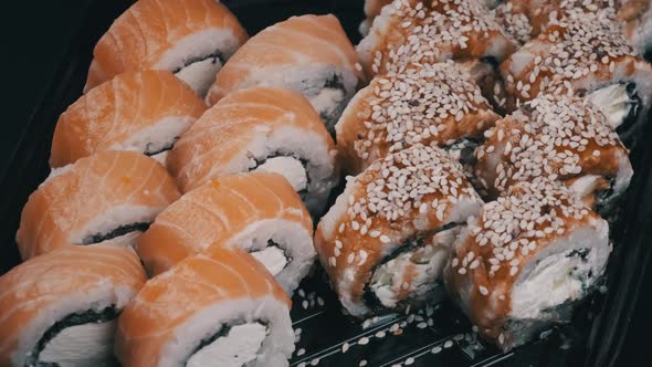 Sushi Rolls Rotating in Plastic Box