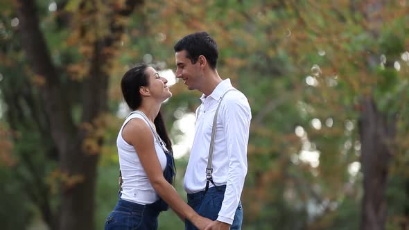 Teen couple kissing in the park in autumn time