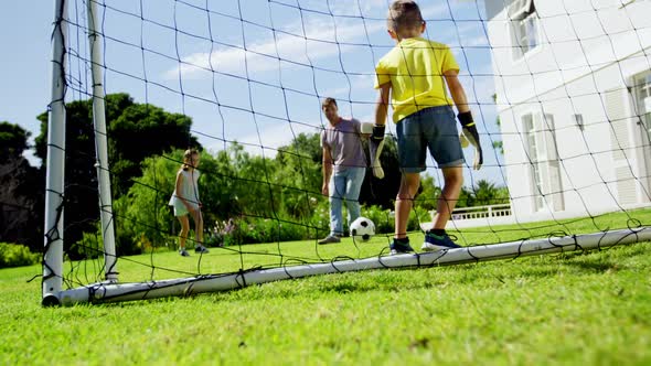 Father and kids playing football