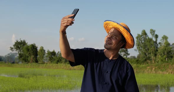 Young farmer man talking on smartphone with feels happy
