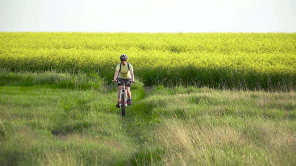 Woman Cyclist Moving On Bike On Countryside