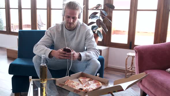 Man listening to music with mobile phone at home