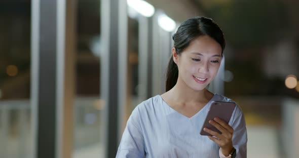 Woman work on cellphone at night