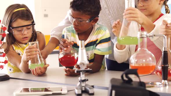 School kids doing a chemical experiment in laboratory