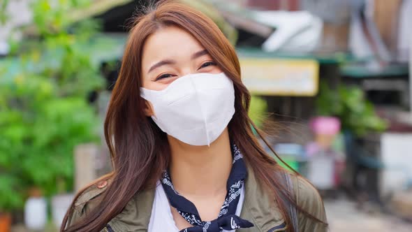 Portrait of Asian attractive woman backpacker wear mask travel in city.