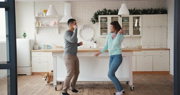 Joyful Man and Woman with Corgi Dog Crazy Fun Dancing at Home