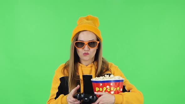 Portrait of Girl in Yellow Hat, 3D Glasses with Popcorn Is Playing a Video Game Using Wireless