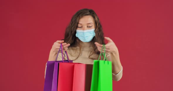 Studio Portrai of Caucasian Happy Woman Shopaholic Teen Girl Shopper Consumer Wears Medical Mask on