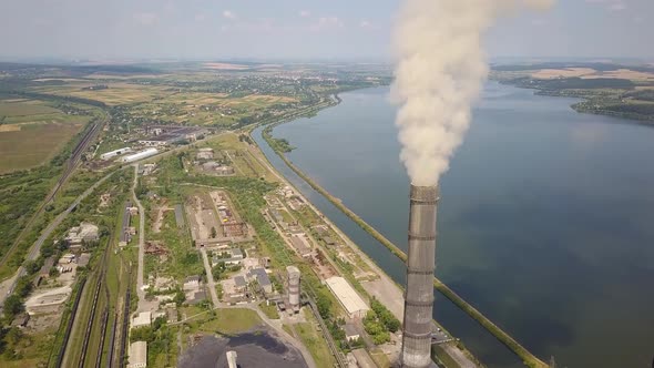 Aerial view of high chimney pipes with grey smoke from coal power plant. Production of electricity