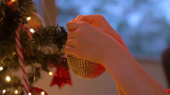 Woman Decorating Christmas Tree with Ball