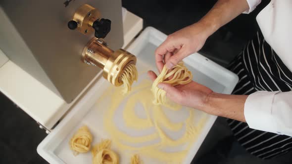 Man Making Fresh Pasta on Traditional Italian Kitchen Machine for Spaghetti Chef Preparing Fresca