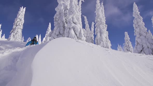 A man skiing down a snow-covered mountain in the winter.