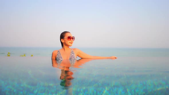 Young asian woman enjoy around outdoor swimming pool for leisure