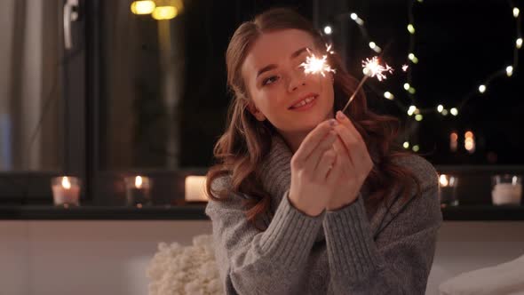 Happy Young Woman with Sparklers at Home