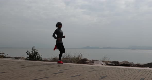 Fitness woman runner running  at the sunrise seaside