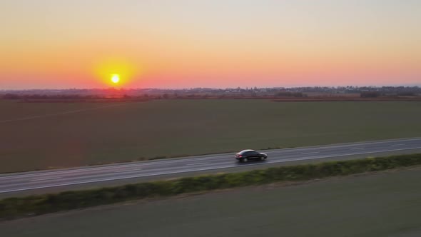 Aerial View of Intercity Road with Fast Driving Cars at Sunset