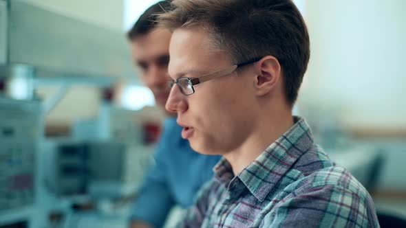 Portrait of a Two Handsome Men Using Laptop in Laboratory