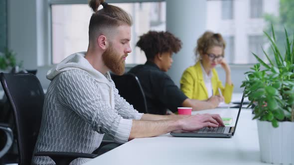 Bearded Man Working in Office and Using Laptop