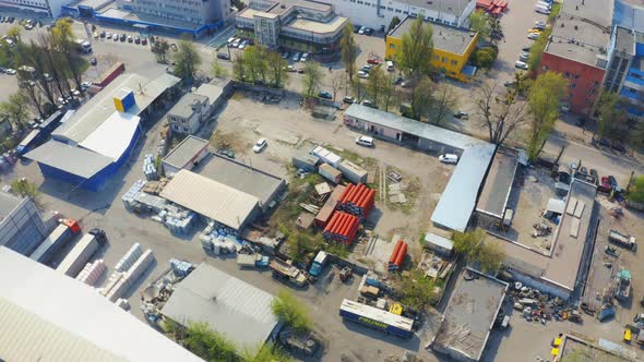 Fly Over Industry Area with Store Buildings and Warehouses. Orange Pipes Laying on the Ground