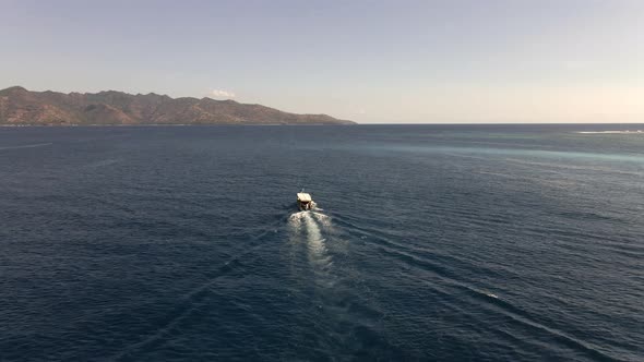 Shuttle boat driving tourist over from Gili Air to Lombok Island.Epic aerial drone shot.