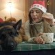 A Young Woman in a Christmas Hat Spends Time with Her Dog Near the Christmas Tree - VideoHive Item for Sale
