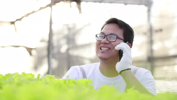Happy owner Asian man farmer checking quality and having a phone call in a hydroponics farm