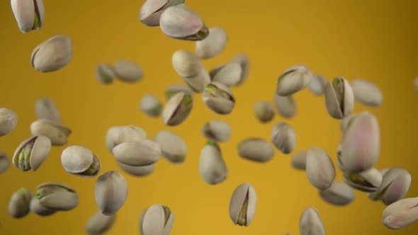 Closeup of the Delicious Salted Pistachios Flying Up on a Yellow Background