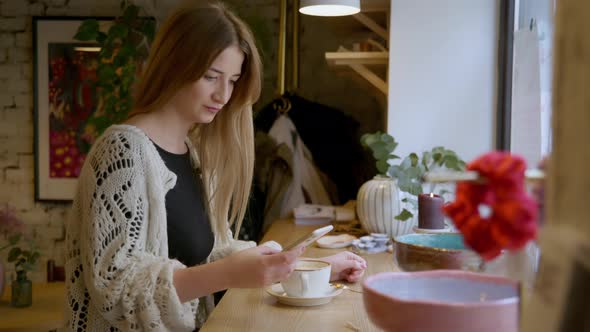 Woman Using Smartphone In a Cafe