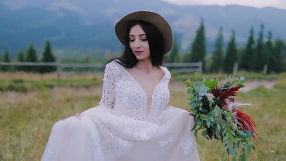 Portrait of lovely dark-haired bride in nature