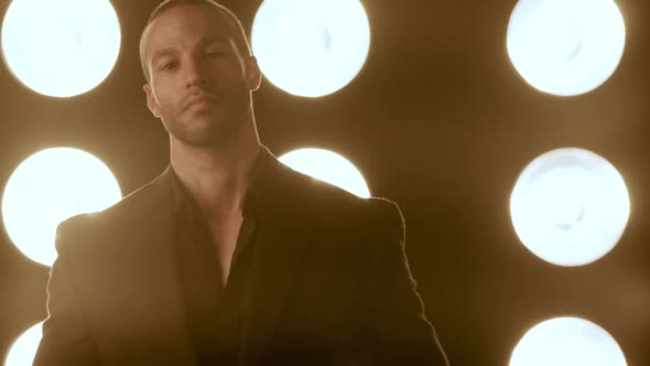 Handsome and stylish man in front of a wall of lights