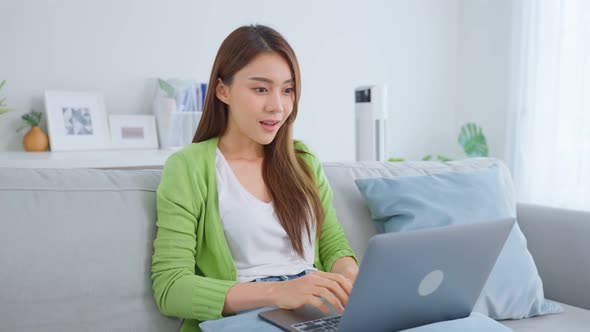 Asian young beautiful woman excited after check good news from laptop.