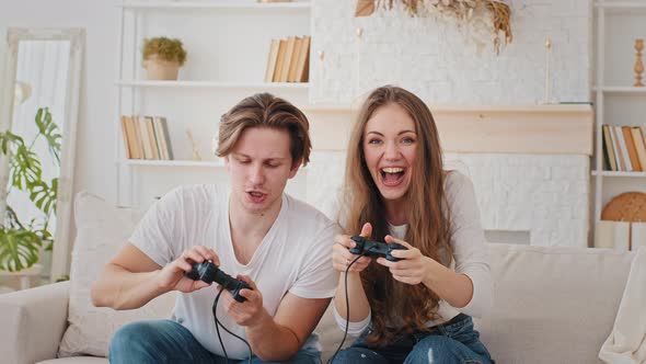 Cheerful Couple Millennials Caucasian Married Man and Woman Playing Videogame Together at Home