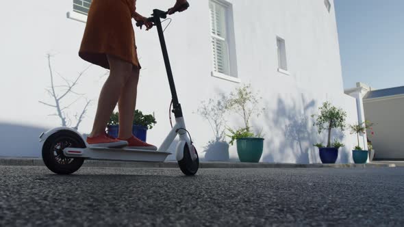 Two mixed race women riding electric scooter