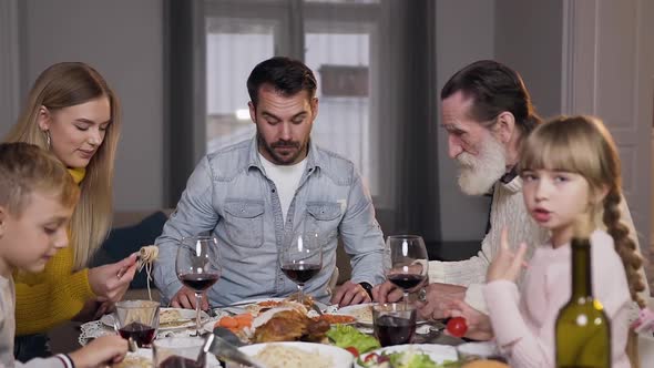 Attractive Happy Different Generation Family Enjoying Dinner Around the Family Feast