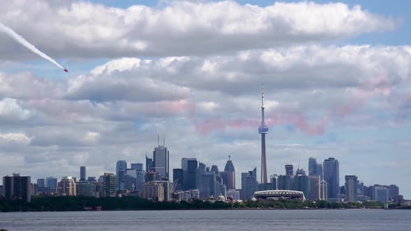 Red Stunt Plane Flying at The CN Tower and Toronto City Skyline, Wide Shot. Air Show fighter pilot s