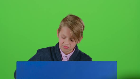 Teenager Peeks Out From Behind the Boards and Shows Dislike on a Green Screen