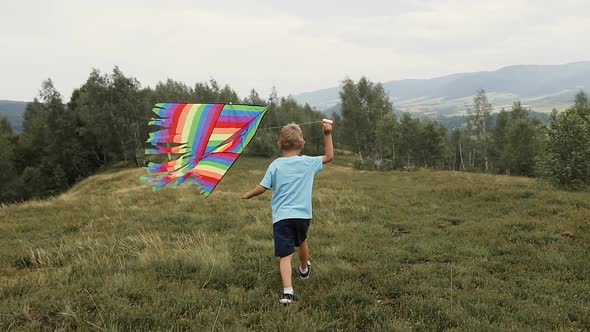 The Boy Runs and Launches a Snake in the Mountains