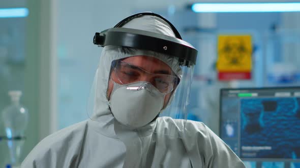Close Up of Tired Chemist Man Doctor in Coverall Working in Lab