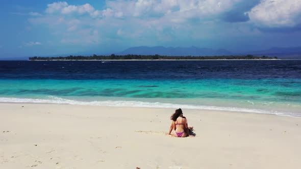 Guy and girl tanning on idyllic shore beach voyage by blue lagoon with bright sand background of Gil