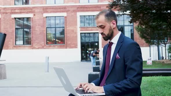 Young Businessman Working on the Laptop in a Business District, Close Up Slow Motion