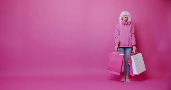 Happy Woman After Successful Shopping with Her Dog Isolated on Pink Background