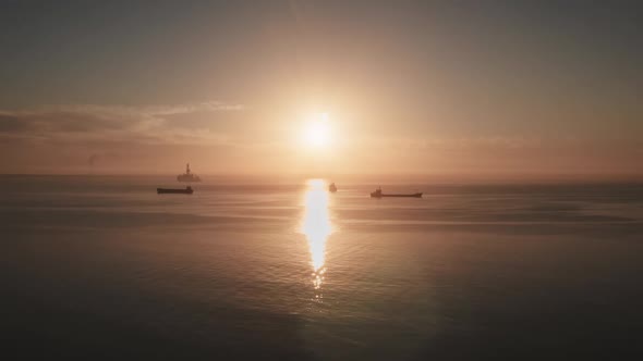 Ocean Orange Sunset Landscape Cargo Ships Sail in Evening Light alt