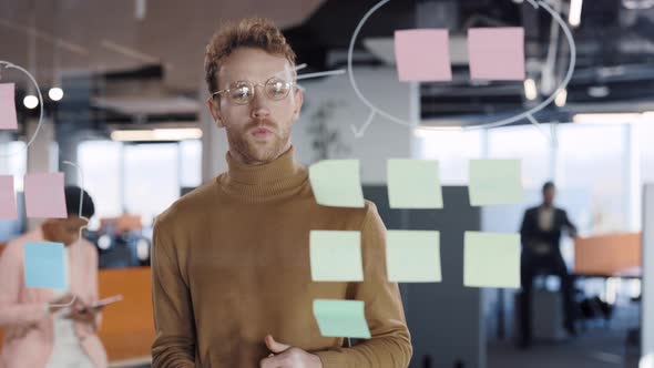 Serious Businessman Manager Examining Information on Sticky Notes and Finding Solution