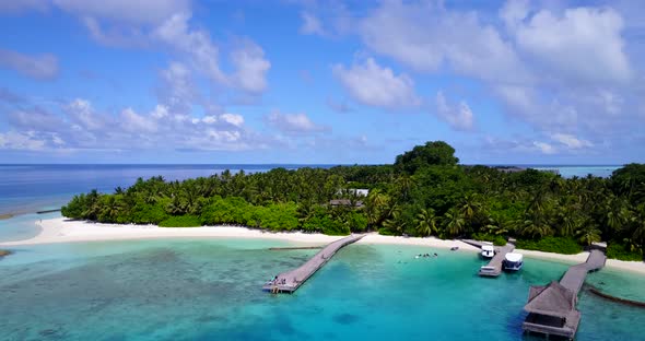 Wide overhead clean view of a white sandy paradise beach and blue ocean background 