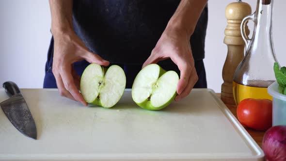 A Piece Of Unpeeled Green Apple Being Cut On Cubes Using Sharp Kitchen Knife. - Close Up