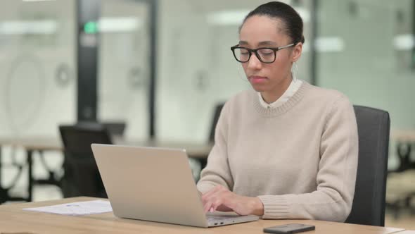 Creative African Woman with Laptop Smiling at Camera