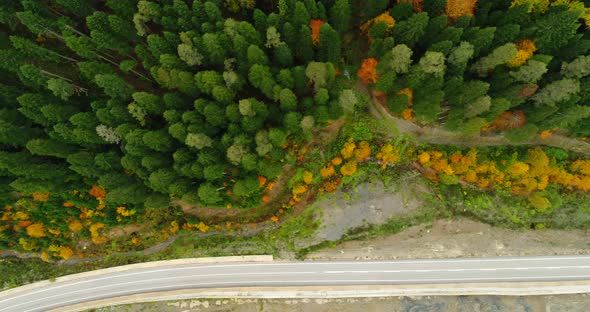 4K Aerial footage of mountain road in beautiful forest at sunset in autumn