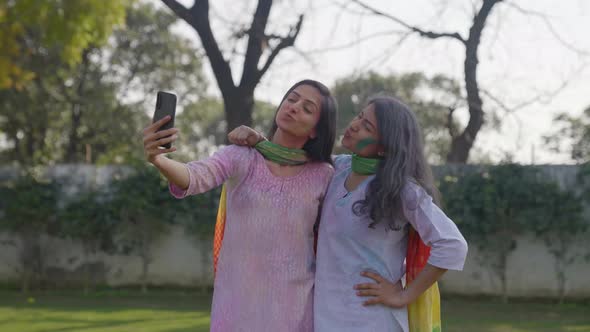 Happy Indian girls taking selfies at a Holi party