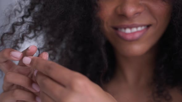 Closeup Shot of Happy Black Woman Playing with Her Afro Hair in White Room